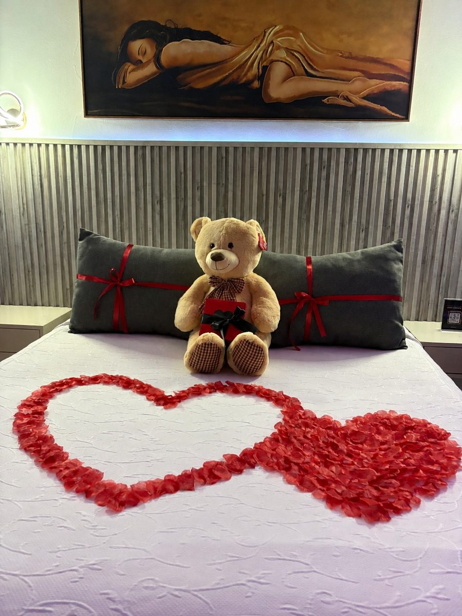 Decoración romántica con oso de peluche y corazones de pétalos